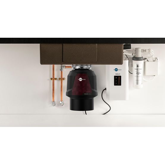 Under-sink kitchen disposal unit with plumbing and electrical components.